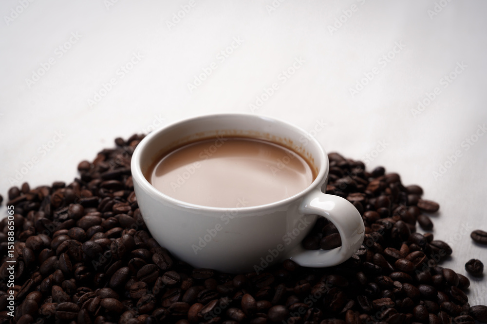 Freshly brewed black coffee in a white cup beside roasted beans on rustic table, capturing morning aroma, warmth, and cozy atmosphere. Freshly brewed black coffee in a white cup beside roasted beans on rustic table, capturing morning aroma, warmth, and cozy atmosphere.