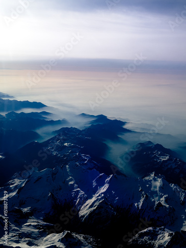 An aerial shot of the Swiss Alps mountain range on a sunny day with blue skies