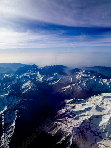 An aerial shot of the Swiss Alps mountain range on a sunny day with blue skies