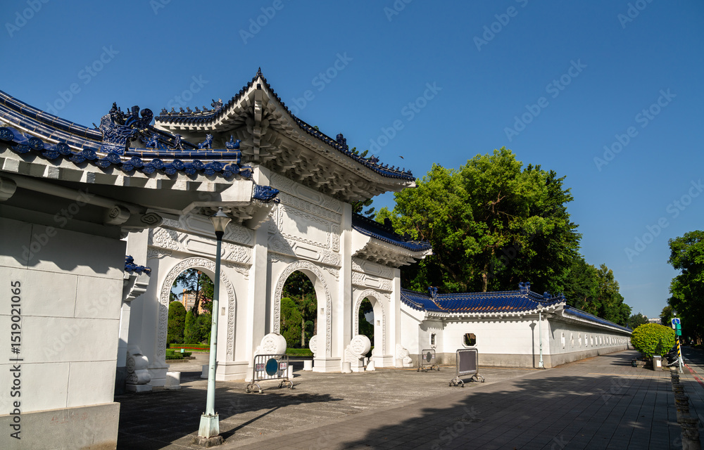 Fototapeta premium Crisp morning view in Taipei, Taiwan, shows a triple-arched white gate with deep-blue tiled roofs and dragon ornaments marking a side entrance to Liberty Square at Chiang Kai Shek Memorial Hall