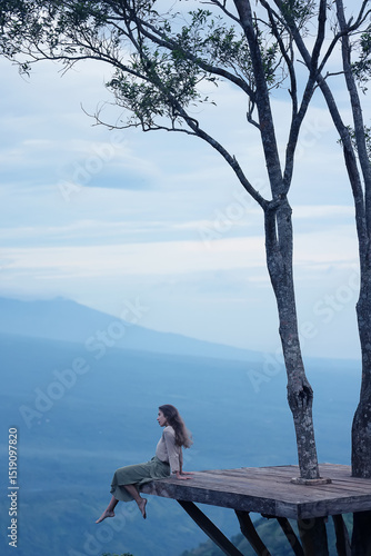 Meditation in the mountains, a girl sits on a platform in the mountains, Bali Indonesia landscape