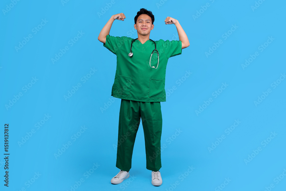 Naklejka premium Portrait of Medical Staff in Scrubs and Stethoscope Flexing Arm Muscle and Feeling Proud
