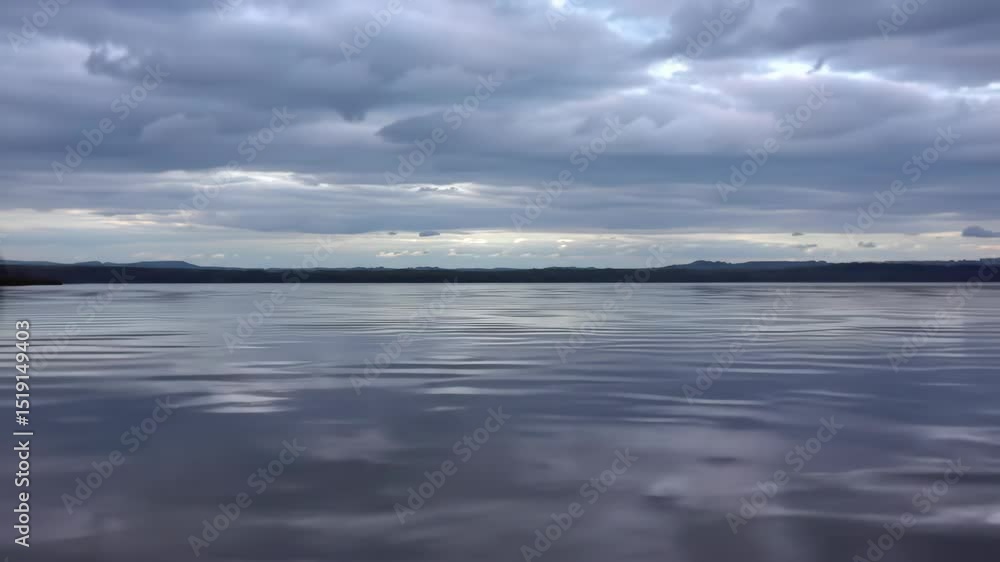 Serene Lake Under Cloudy Sky with Reflections and Distant Mountains Serene Lake Under Cloudy Sky with Reflections and Distant Mountains