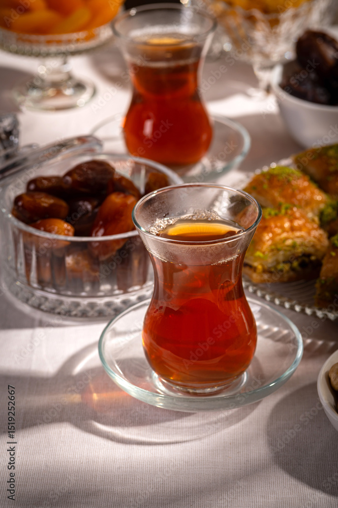 Traditional Turkish Tea with Dates and Oriental Sweets on Festive Table Traditional Turkish Tea with Dates and Oriental Sweets on Festive Table