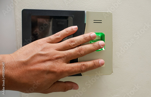 A person scans their fingerprint on a biometric access control system, emphasizing modern security technology and identity verification in workplaces or restricted areas.