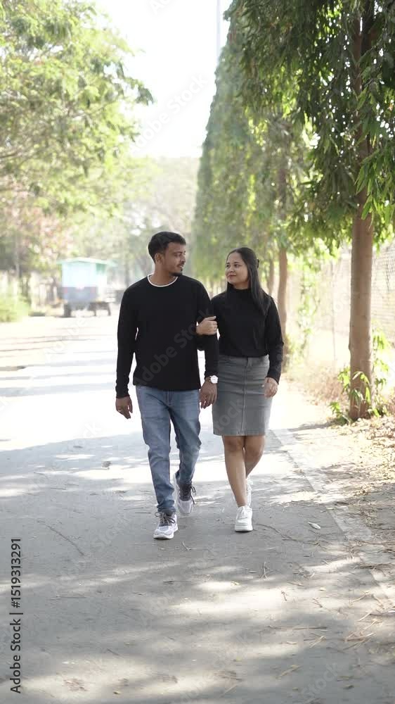 young couple lovingly embracing while standing on a quiet, tree-lined path on a sunny day young couple lovingly embracing while standing on a quiet, tree-lined path on a sunny day