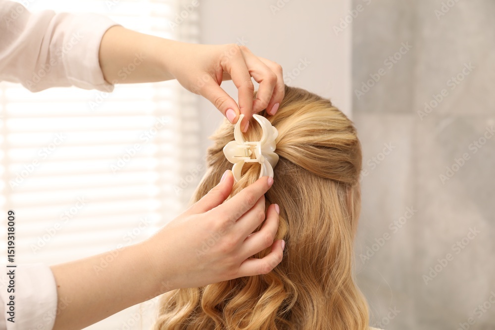 Fototapeta premium Hairdresser styling woman's hair in salon, closeup