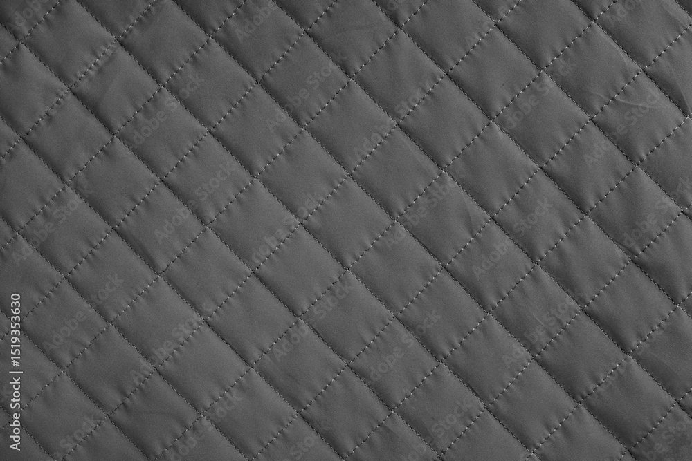 Naklejka premium Checkered, diamond stitching pattern, black quilted fabric background. Blanket or puffer jacket, stitch rhombus texture close up, macro. Wallpaper, backdrop.