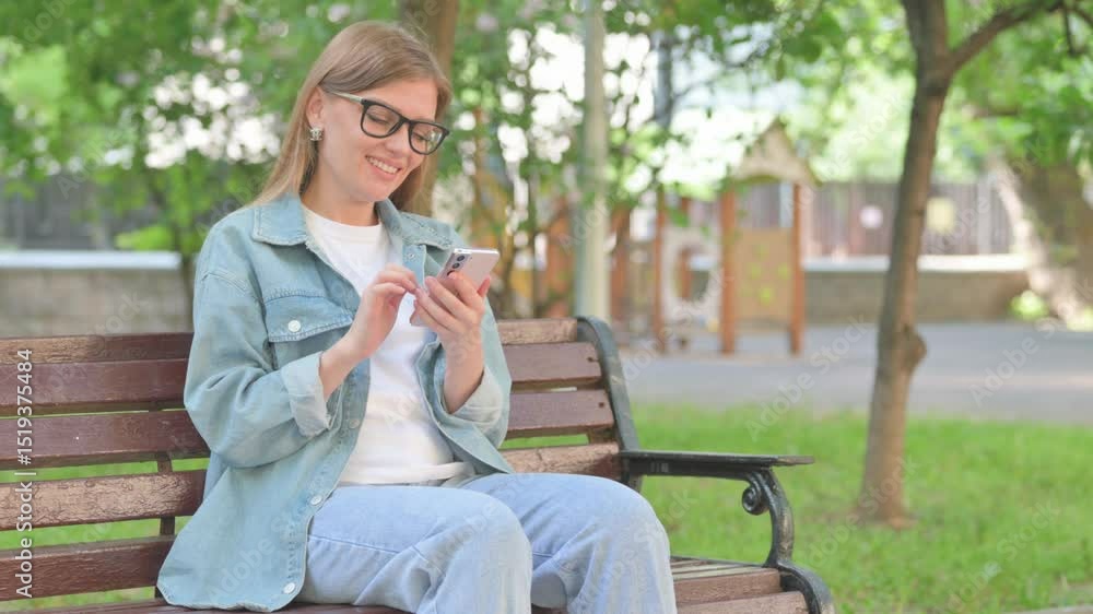 Young Woman Using Phone on a Park Bench Young Woman Using Phone on a Park Bench