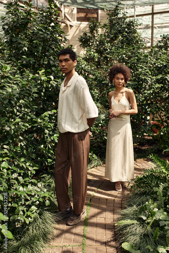 Obraz premium Young couple shares a tender moment in a lush greenhouse filled with vibrant greenery