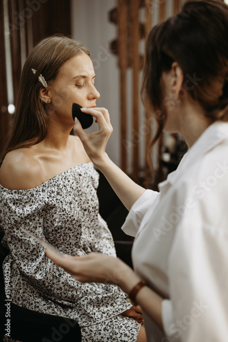 Makeup artist at work. Makeup artist prepares model skin