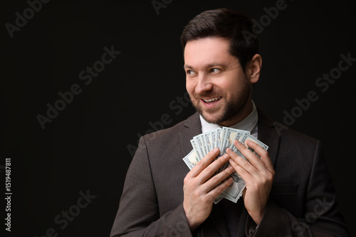 Vászonkép Happy greedy banker with dollar banknotes on black background