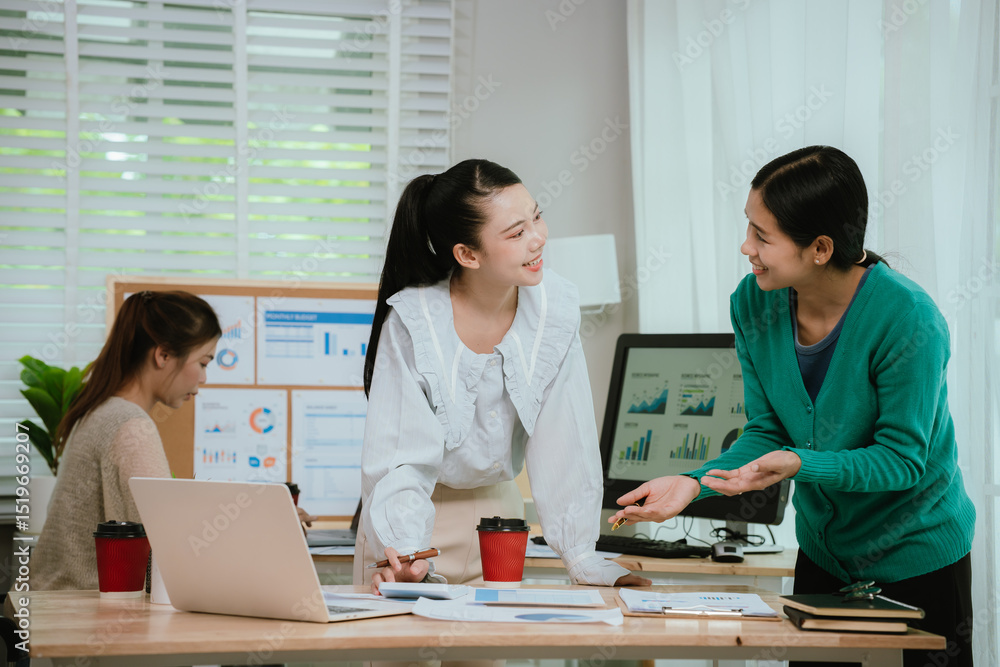 Fototapeta premium Diverse business team in modern office collaborating on startup strategy, analyzing charts, discussing growth, and planning successful marketing project.