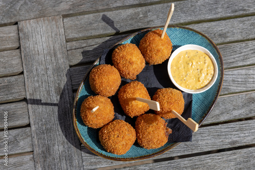 Dutch bitterbal in a bowl; traditional fried pub snack appetizer with mustard
