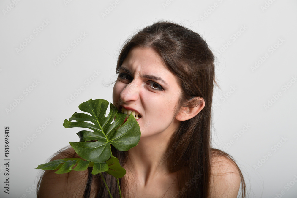 frau biesst in ein blatt verzweifelter vegetarier portrait witzig frau biesst in ein blatt verzweifelter vegetarier portrait witzig