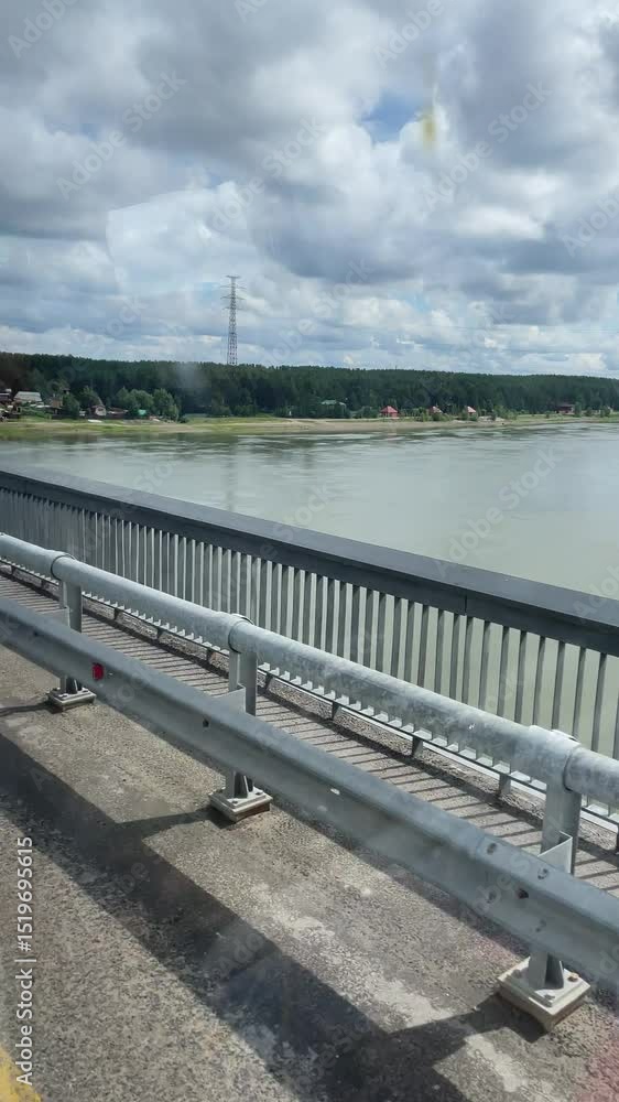 Serene Riverside View from a Bridge with Lamppost Framing a Picturesque Landscape Under a Partly Cloudy Sky Serene Riverside View from a Bridge with Lamppost Framing a Picturesque Landscape Under a Partly Cloudy Sky
