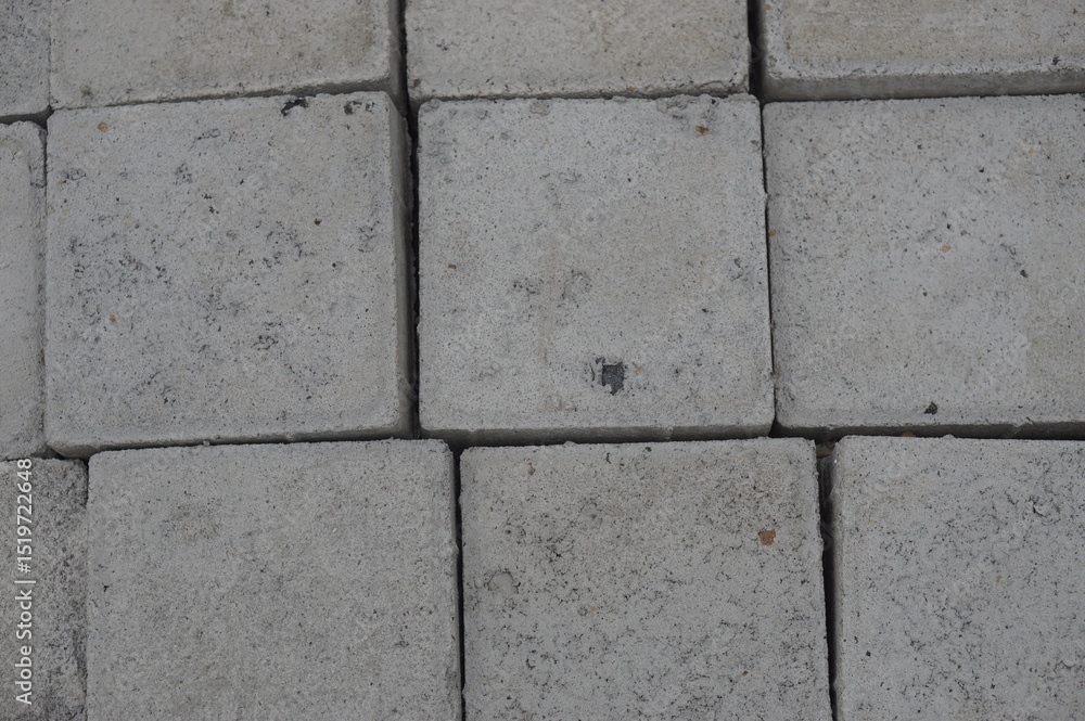 A variety of concrete products—triangular bricks, cylindrical pipes, and rectangular blocks—neatly arranged and ready for use in construction and infrastructure projects. These materials reflect durab A variety of concrete products—triangular bricks, cylindrical pipes, and rectangular blocks—neatly arranged and ready for use in construction and infrastructure projects. These materials reflect durab