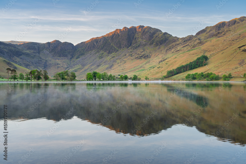Naklejka premium Morning reflections in calm lake at Buttermere in The Lake District National Park, UK.