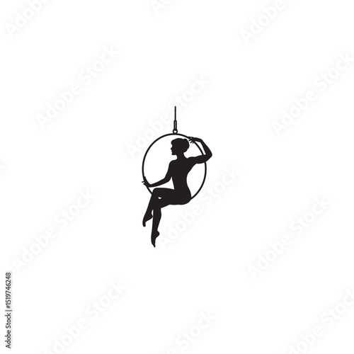 Silhouette of an elegant aerialist performing in the hoop for circus or pole dance