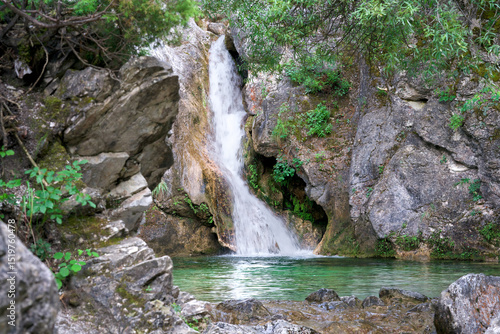 Orlias waterfall, Mount Olympus, Greece: cascade into pristine turquoise pool. Clear water over rocks in mythical mountain park near ancient Dion. Natural beauty, refreshing gorge stream, hiking spot.