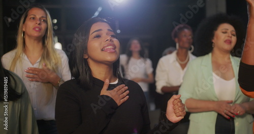 People raising hands and singing passionately in worship during church service, expressing faith and devotion in a diverse and inclusive community setting