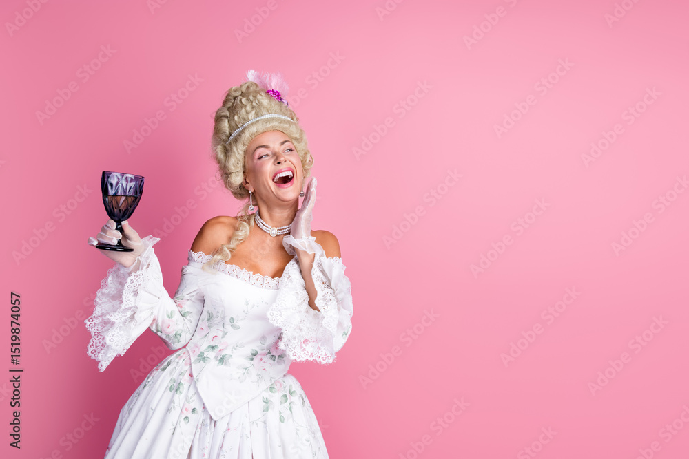 Fototapeta premium Graceful woman in vintage Baroque costume holding a glass against a pink background, combining historic charm with a modern aesthetic