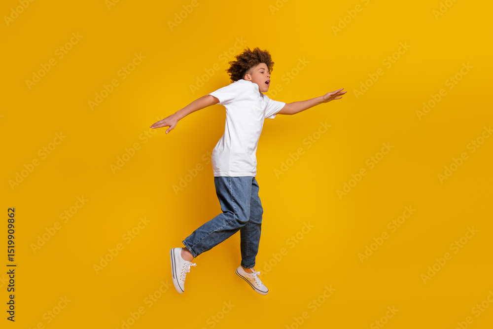 Young boy jumping with enthusiasm against a vibrant yellow background, showcasing modern casual fashion in a dynamic pose. Young boy jumping with enthusiasm against a vibrant yellow background, showcasing modern casual fashion in a dynamic pose.