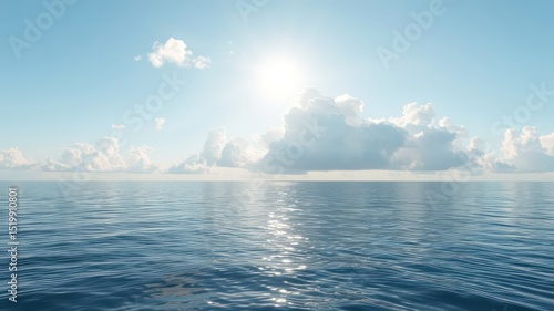 Fototapeta Naklejka Na Ścianę i Meble -  Calm, blue ocean water reflects the sunlight under a soft blue sky filled with gentle, puffy white clouds along the distant horizon