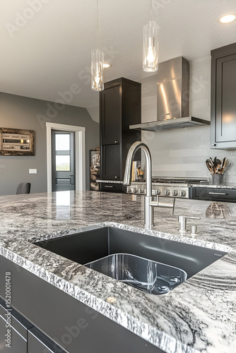 A contemporary kitchen with a large kitchen island, integrated cooktop, and deep undermount sink