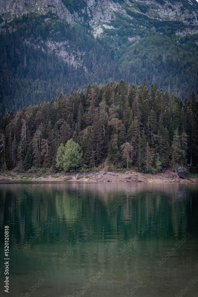 Fototapeta premium The Black Lake, Durmitor in Montenegro. The lake with crystal-clear water reflecting the stunning surrounding mountains. And Bobotov Kuk peak towers over the lake.