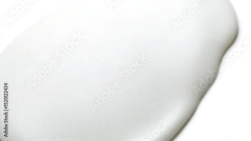 Smooth white substance being poured onto a flat surface with a clean background