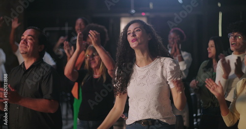 Diverse group of people standing and clapping hands in a spiritual gathering, joyful celebration of unity and faith, ethnic inclusion, community bonding during worship