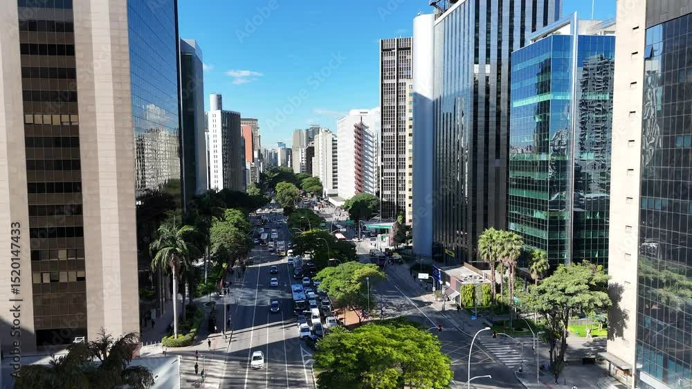 Visão aérea da movimentada Avenida Faria Lima em São Paulo, SP, mostrando a dinâmica urbana, arquitetura moderna e o fluxo intenso de veículos e pedestres no coração financeiro da cidade