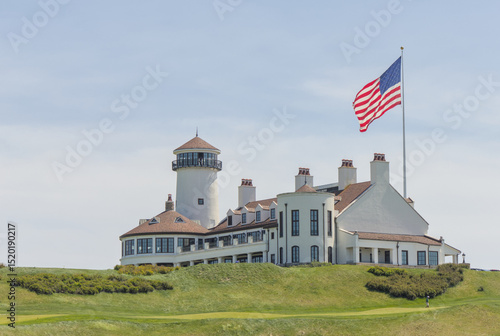 white building on green meadow grass hill next to american flag of the united states of america usa golf course next to hudson river bayonne new jersey