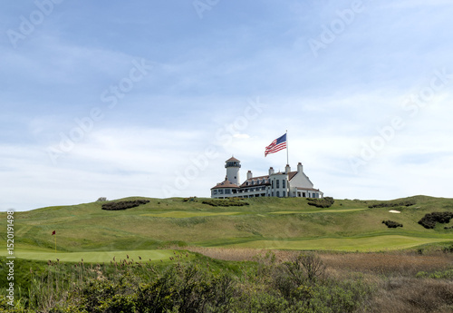 white building on green meadow grass hill next to american flag of the united states of america usa golf course next to hudson river bayonne new jersey