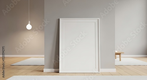 Interior view featuring a blank white picture frame against a gray wall illuminated by soft lighting in a minimalist setting with wooden floors.
