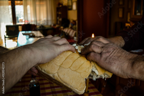 Photography Father and son ceremonially tearing the Slava bread as part of the traditional S