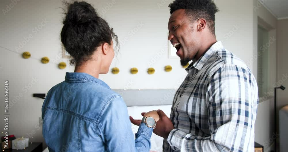 Diverse couple reacting to wrist grab, hugging, kneeling, sampling charcuterie board in bedroom Diverse couple reacting to wrist grab, hugging, kneeling, sampling charcuterie board in bedroom