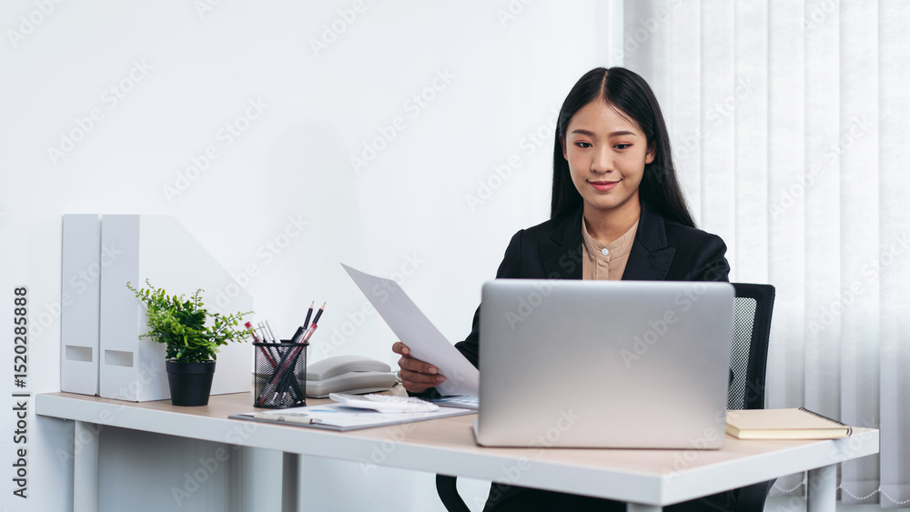 Business woman working on document to reading financial chart and typing summary report on laptop Business woman working on document to reading financial chart and typing summary report on laptop