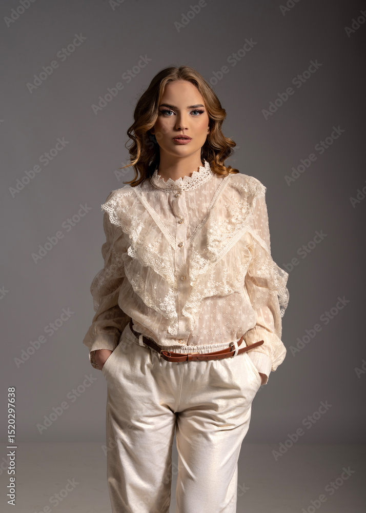Fashion model posing in studio wearing white lace shirt and white pants Fashion model posing in studio wearing white lace shirt and white pants
