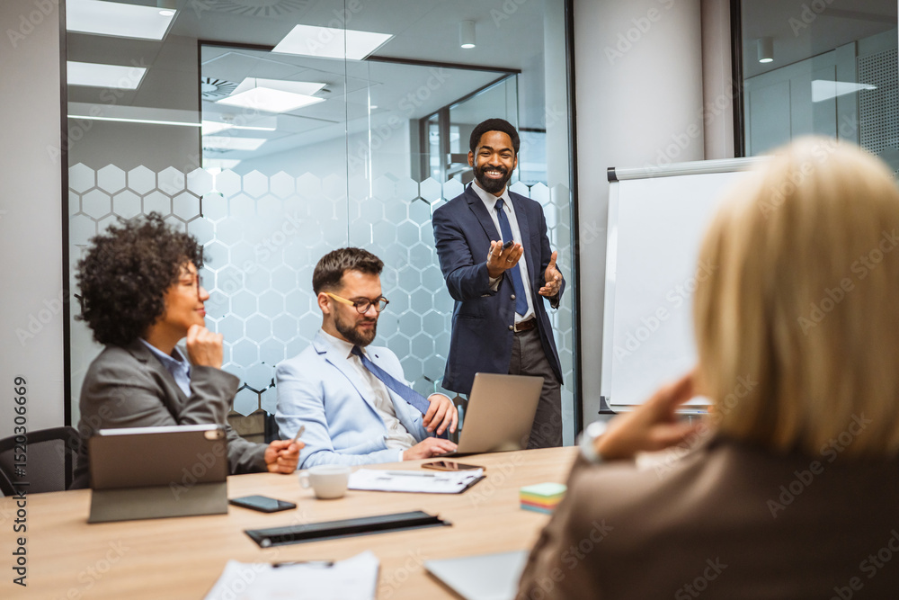 Focused businessman give a presentation to his colleagues in an office Focused businessman give a presentation to his colleagues in an office