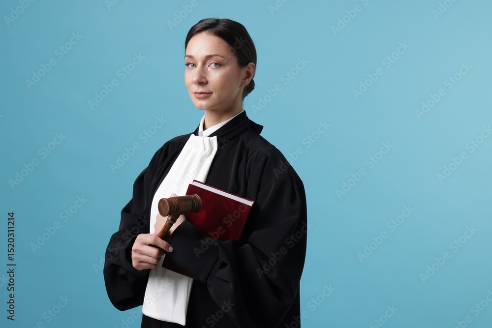 Judge with mallet and book on light blue background Judge with mallet and book on light blue background