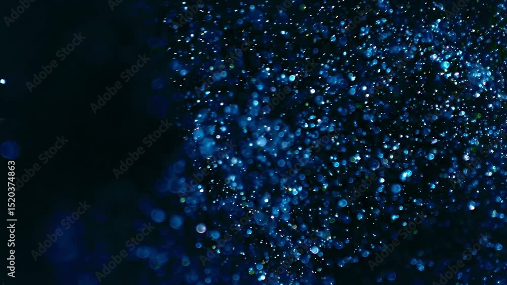 Ethereal blurred dust particles floating and swirling in the air. Blurry sparkling blue glitter creating a bokeh of lights with flowing dynamic motion. Magical abstract background glowing blue. Loop.