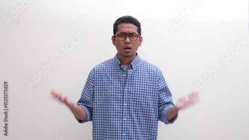 Adult Asian man shaking head showing confused and disbelief expression