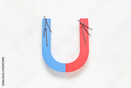 Magnet with nails on white ...