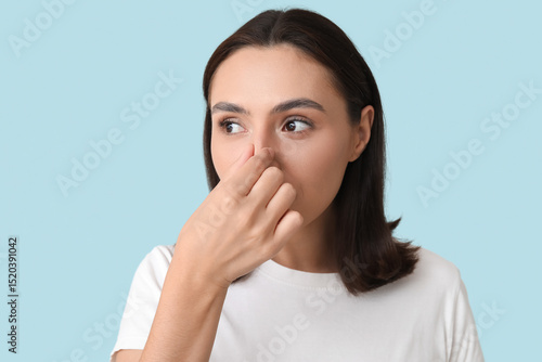 Young woman touching her no...