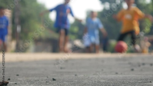 blur a group of boys playing football in the street