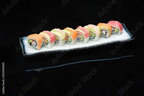 rainbow california avocado inside-out sushi roll ont the plate