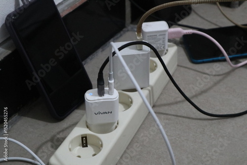 Jepara, 22 Juni 2025  - smartphone charger plugged into an electrical terminal