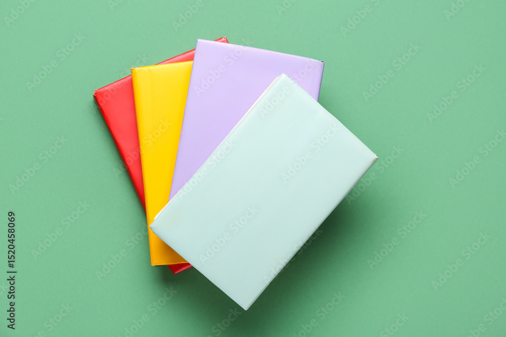 Many colorful books on green background Many colorful books on green background